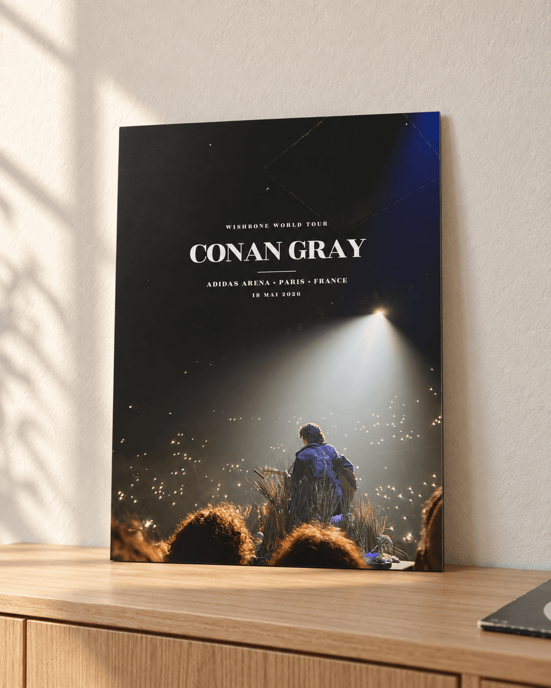 Exemple d’affiche Conan Gray du 18 mai 2026 à l’Adidas Arena, imprimée sur panneau rigide et posée sur un meuble