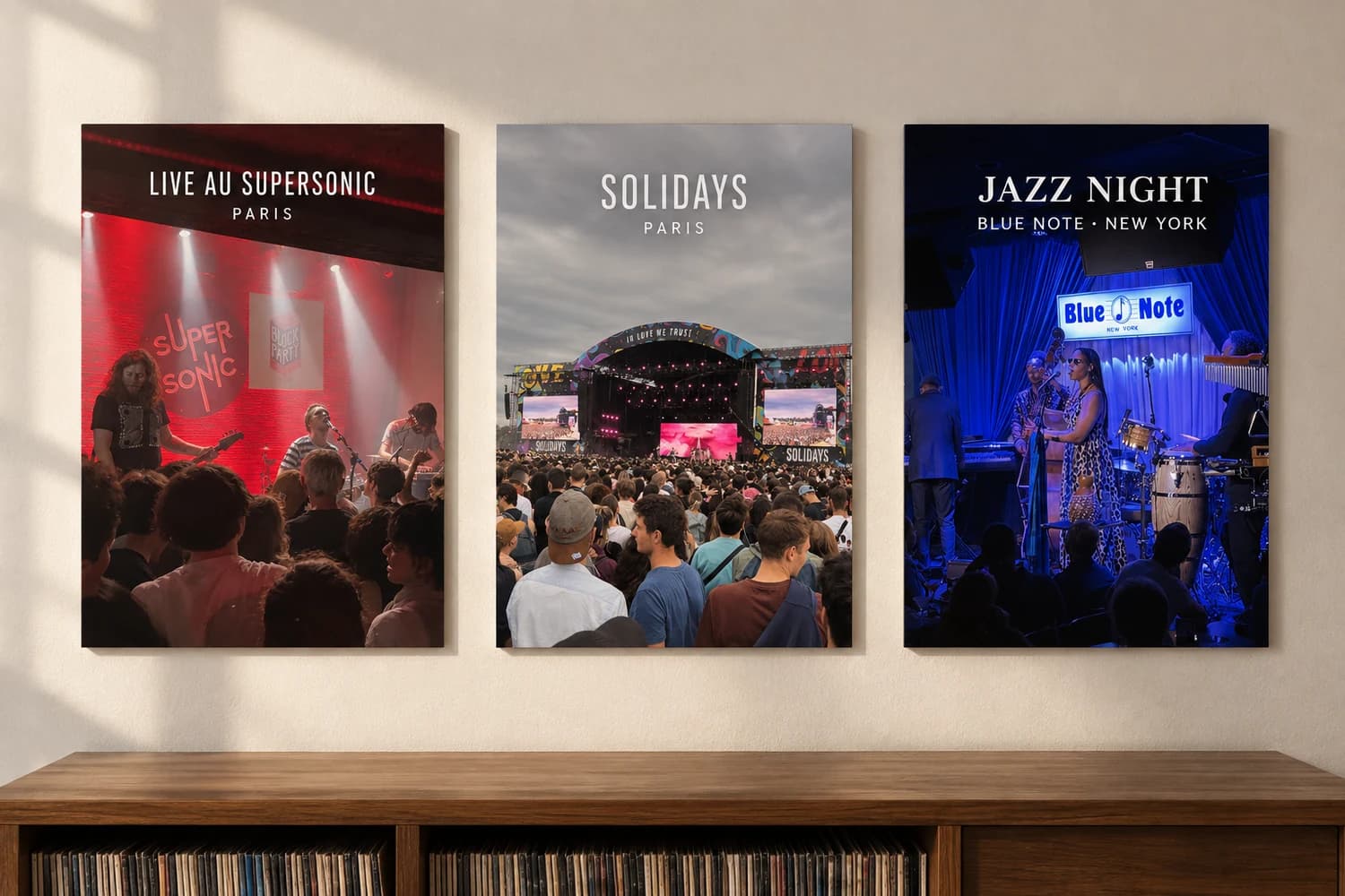 Trois affiches de concerts rouges, claires et bleues alignées au-dessus d’un meuble à vinyles